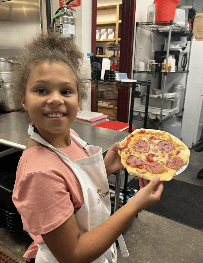 Nolavore camper holds up pizza she made